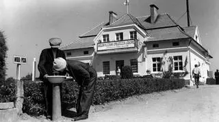 Dwóch mężczyzn pijących wodę ze studzienki podczas otwarcia wystawy "Kultura i praca wsi w Liskowie", 1937.06