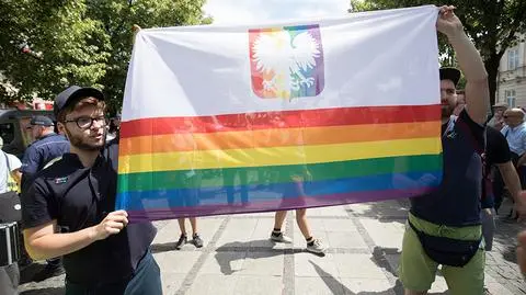 Tęczowa flaga z białym orłem na marszu w Częstochowie