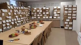 Sala konferencyjna w CLKP, pełna kartonów z pakietami próbek biologicznych