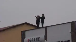Świadkowie robią zdjęcia z dachów pobliskich budynków