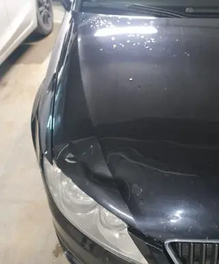 Wgniecenie i krople deszczu na masce seata
