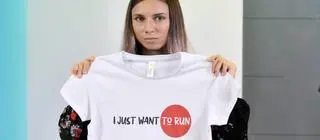 Tsimanouskaya holding a t-shirt saying "I just want to run"