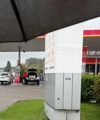 Wiceminister sportu Jacek Osuch tankuje benzynę do kanistrów