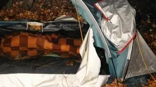 Mężczyzna przykryty był kocem w pomarańczowo-szarą kratę 