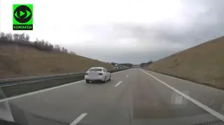 Kierowca BMW wyprzedza ciężarówkę pasem awaryjnym na autostradzie