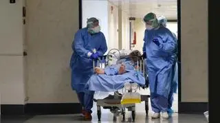 Szpital w Berscii. Personel medyczny transportuje zakażonego koronawirusem