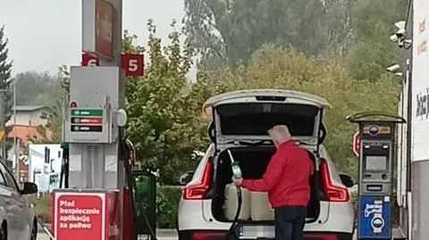 Wiceminister sportu Jacek Osuch tankuje benzynę do kanistrów
