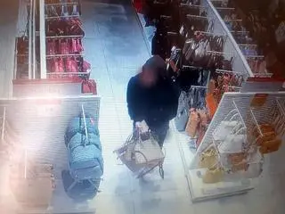 Mężczyzna wynosi damskie torebki - zdjęcie ze sklepowego monitoringu
