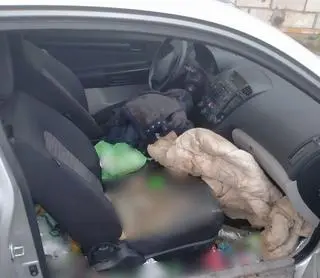 Mężczyzna siedział w aucie. Był częściowo rozebrany