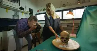 Petrone w swoim laboratorium i jedna z czaszek ofiar