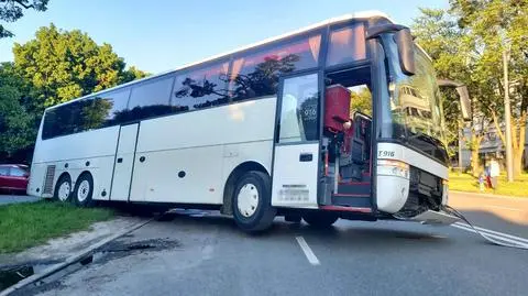 Autokar wjechał w dziurę i zawisł nad jezdnią