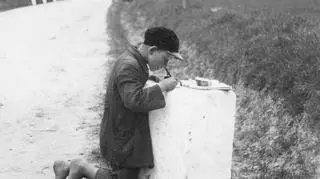 Uczeń podczas odrabiania lekcji na kamieniu kilometrowym, 1931