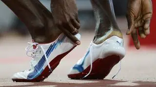 Usdain Bolt zdejmuje buty po biegu