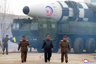 Przywódca Korei Północnej Kim Dzong Un na tle pocisku balistycznego