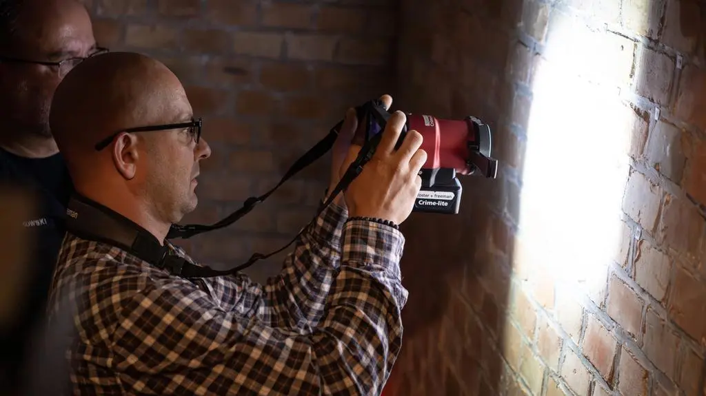 Policyjni eksperci fotografują ściany