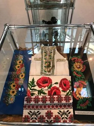 W gablotach prezentowane są chociażby kolorowo haftowane koszule