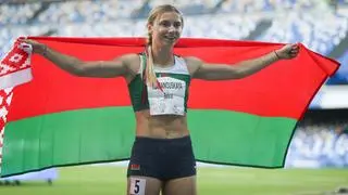 Krystsina Tsimanouskaya holding a Belarusian flag