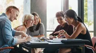 stock-photo-happy-young-university-students-studying-with-books-in-library-group-of-multiracial-people-in-522554425