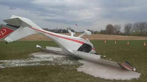 Mały samolot do góry kołami. Na pokładzie dwie osoby
