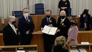 Marszałek Senatu Tomasz Grodzki przekazał Adamowi Bodnarowi tekst uchwały i honorowe odznaczenie 