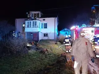 Strażak nałożył odzież zabezpieczającą przed COVID-19