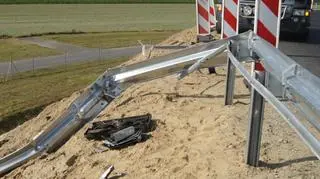 Przerwane barierki z elementami samochodu