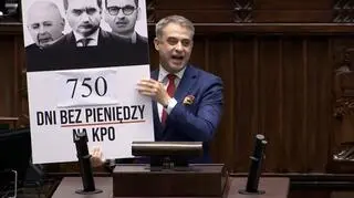 Krzysztof Gawkowski z tablicą na mównicy
