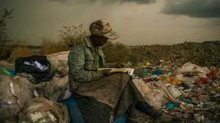 03.04.2012, Nairobi, Kenia, przerwa w pracy na wysypisku śmieci, kobieta przegląda jeden ze znalezionych tam katalogów.
