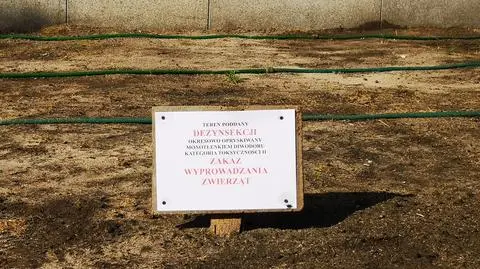 Tabliczka ostrzegawcza przed muzeum. "Teren okresowo opryskiwany monotlenkiem diwodoru"