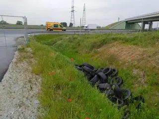 Zużyte opony przy drodze serwisowej