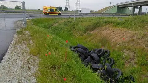 Zużyte opony przy drodze serwisowej