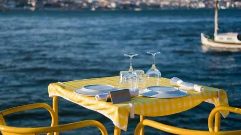 stolik restauracja morze kieliszki para kolacja shutterstock_1273310179