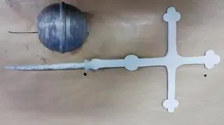 The paper and the coin were placed inside the orb attached to the cross