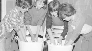 Dziewczynki piorą w miskach na koloniach w Warszawie