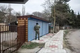 Pogranicznik przy drodze na plażę w wiosce Praskowiejewka. Nieopodal znajduje się "pałac dla Putina" 