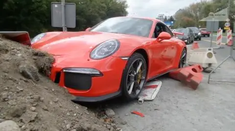 A luxurious red Porsche has been left unattended in the middle of a street