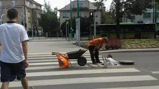 Robotnik wychodzi ze studzienki na działającej nitce ul