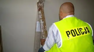 Policjant trzyma deskę, którą mężczyzna zabił psa