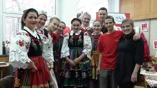 Darczyńcy śpiewający kolędy przy wręczaniu paczek