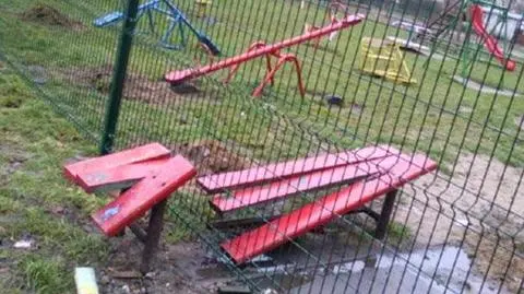 Ławeczka przecięta ogrodzeniem