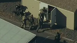 Oddział policji sprawdza jedno z pomieszczeń w pobliżu głównego budynku szkoły w Newtown