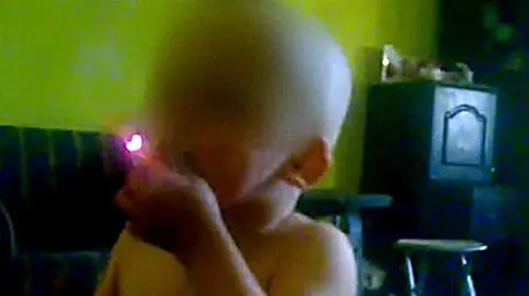 Trzylatek zaciąga się papierosem. Ojciec kręci