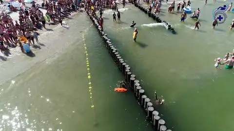 Ratownicy demonstrują głębokość wody przy falochronie 