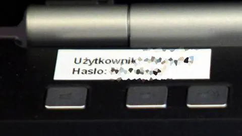 Premier trzyma hasło i login na kartce przyklejonej do laptopa