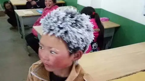 Pokryty szronem zmarznięty chłopiec Ice Boy ukazuje ubóstwo w Chinach