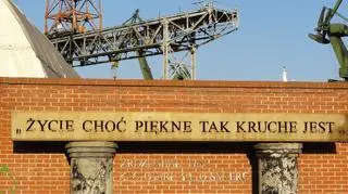 Część pomnika, w tym kolumny i metalowa belka, pochodzą ze spalonej hali