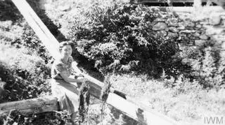 Christine Granville (hrabina Krystyna Skarbek) siedząca przy kanale wodnym w pobliżu wysadzonego mostu w Embrun, Alpy Wysokie, sierpień 1944 r.