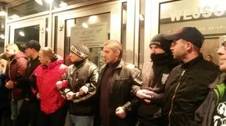 Grupa osób blokuje wejście do teatru