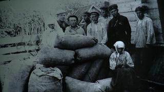 Hołodomor. Aktywiści przy skonfiskowanym "kułackim" ziarnie, początek lat 30. XX wieku