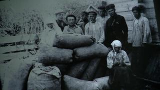 Hołodomor. Aktywiści przy skonfiskowanym "kułackim" ziarnie, początek lat 30. XX wieku